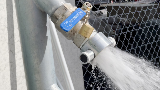 A flow test being carried out on a fire hydrant - a device has been inserted and a stream of water is flowing out of the device