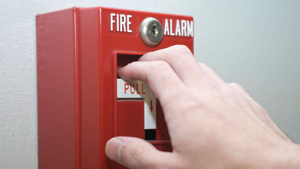 A hand pulling a fire alarm
